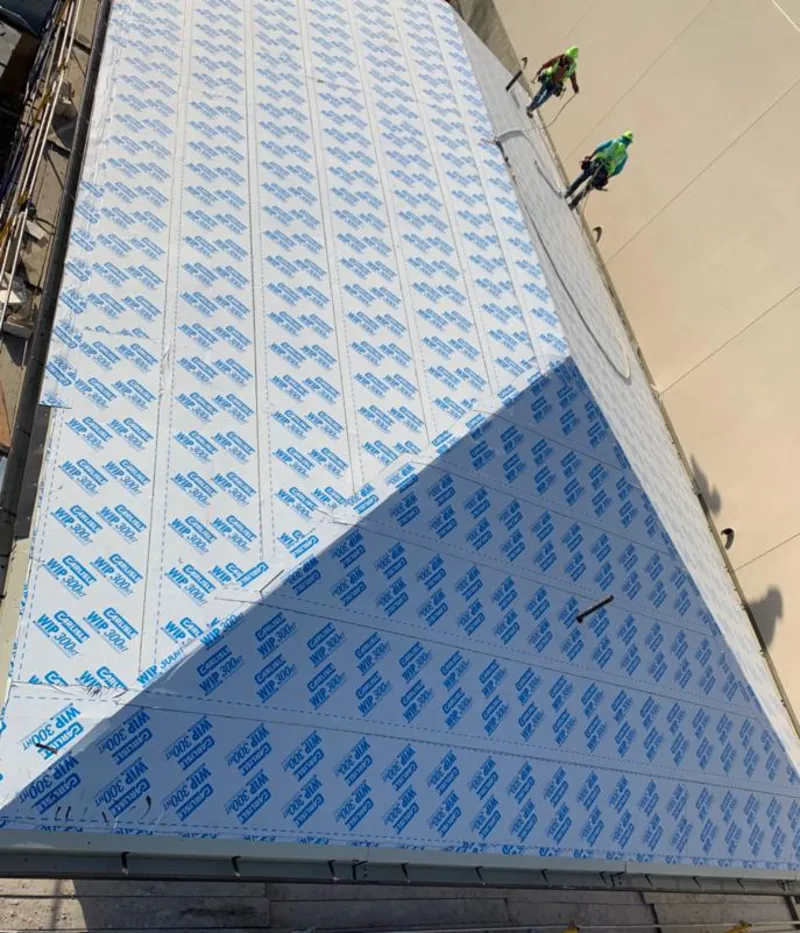 Professional roofers installing underlayment on a metal roof in Mexico